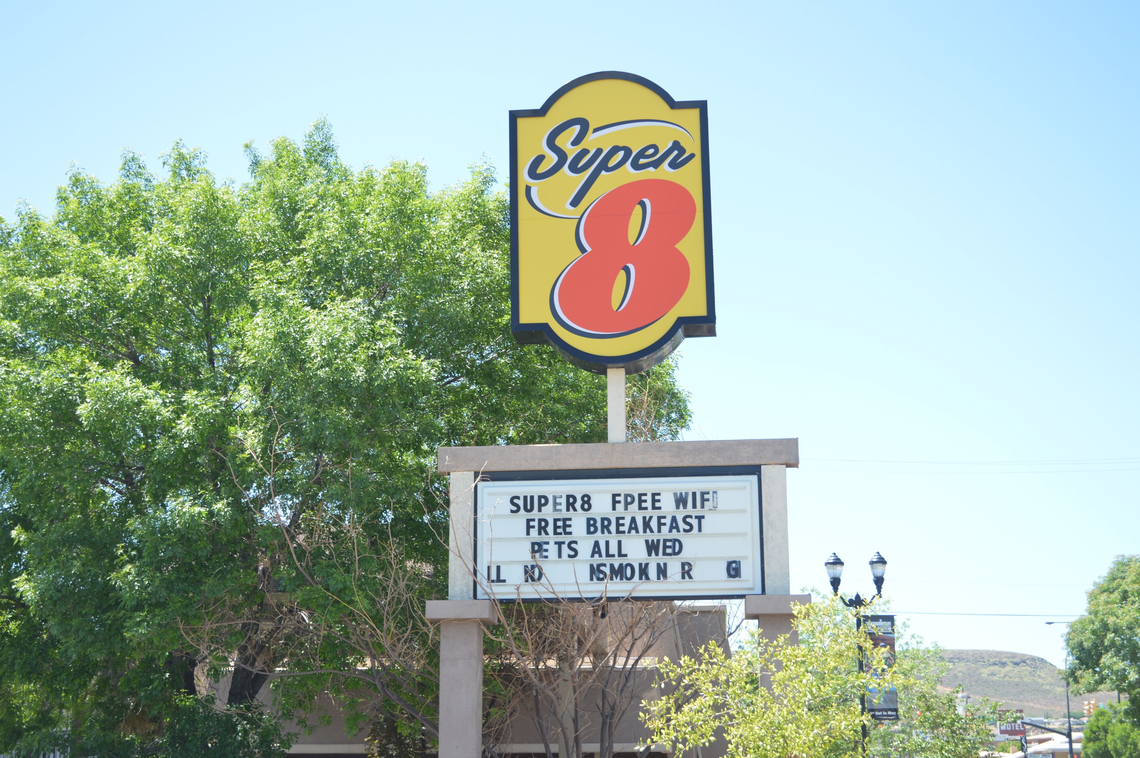 Un letrero de 'Super 8' que anuncia WiFi gratuito, desayuno y admisión de mascotas.