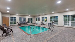 An indoor swimming pool with a tiled floor, surrounded by chairs and a fitness machine. - Super 8 by Wyndham San Antonio/Alamodome Area (San Antonio)