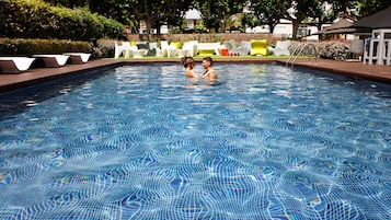 Een buitenzwembad, parasols voor strand/zwembad