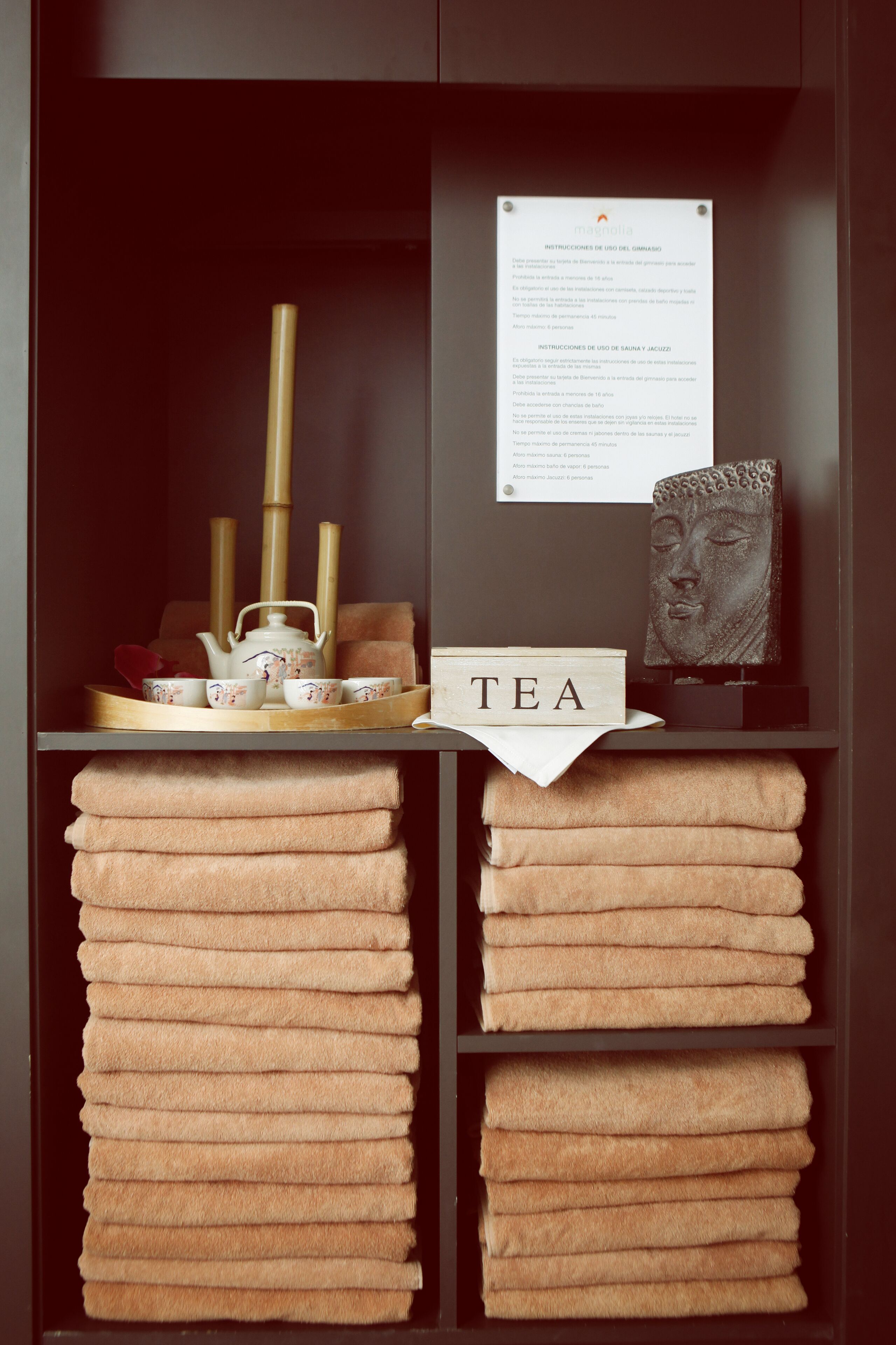 A neatly organized tea station with a tray, teapot, cups, and a sign that reads "TEA".