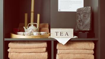A neatly organized tea station with a tray, teapot, cups, and a sign that reads "TEA".