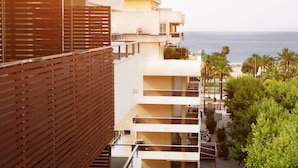 A multi-story hotel with balconies overlooking a beach.