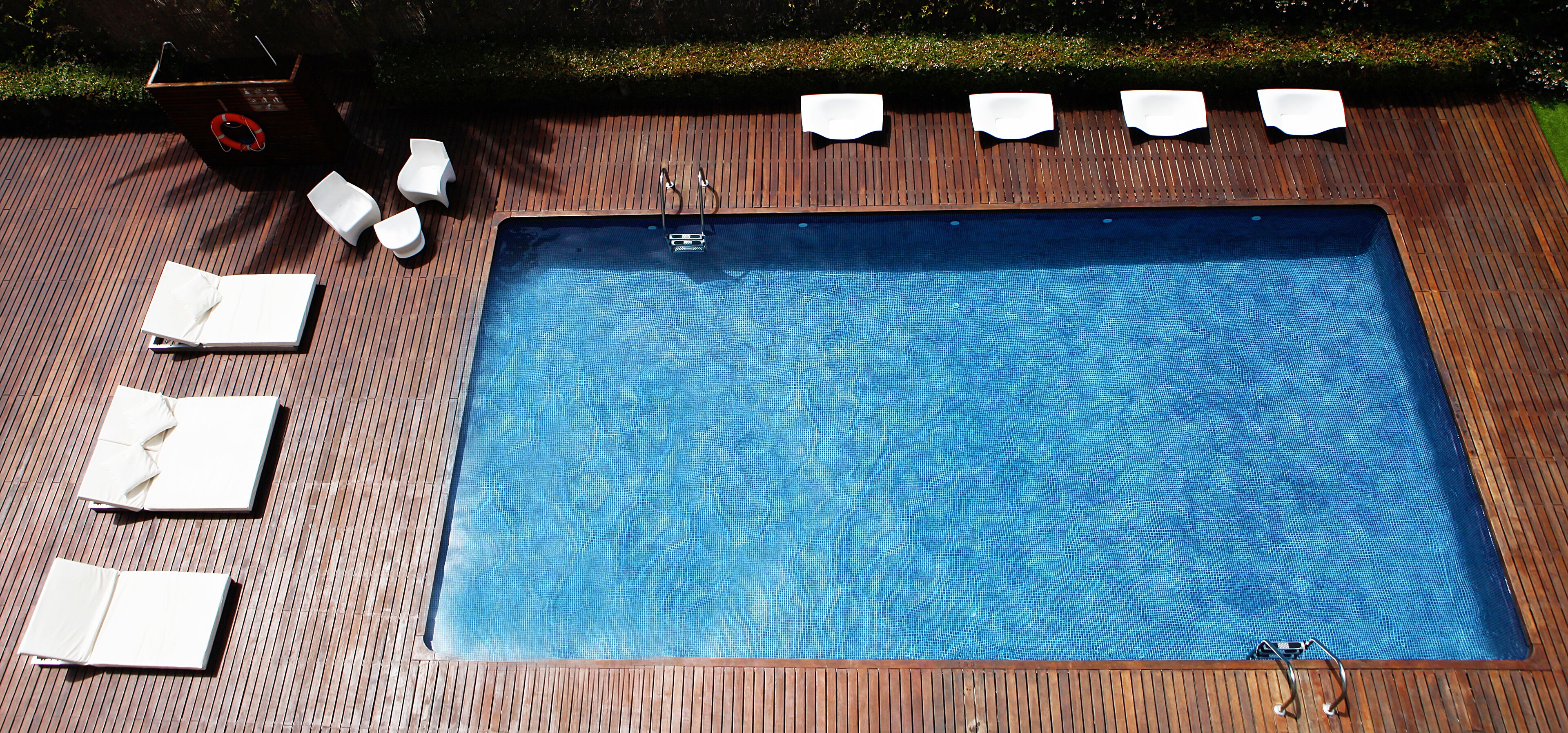 En rektangulär swimmingpool med ett trädäck runt om.