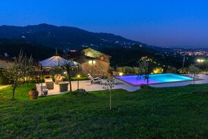 Una casa con piscina, area relax all'aperto e vista sulle montagne.