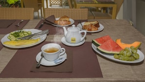 A breakfast setting with plates of food, a teapot, and a cup of tea. - Hotel Vittoria (Viareggio)