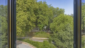 A window with a view of a road and trees. - Hotel Vittoria (Viareggio)