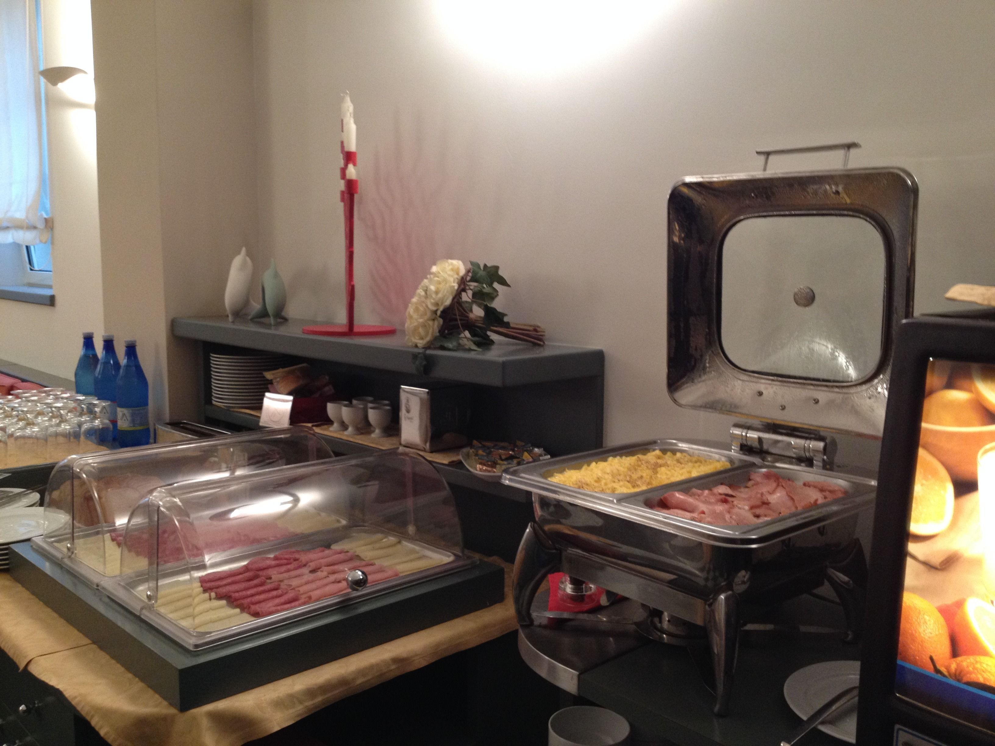 Un buffet proposant une variété de plats, notamment des viandes et des œufs, ainsi qu’un assortiment de fruits.