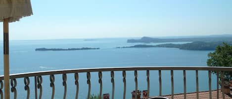 Un balcón con vista a un mar tranquilo y a islas lejanas.