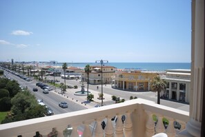 A coastal cityscape with a view of the sea, a busy street with cars, and buildings with balconies. - Villa Tina (Viareggio)