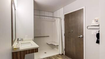 A modern bathroom with a shower, a sink, and a door.