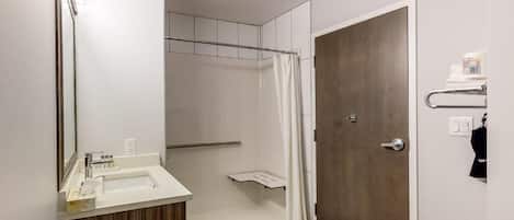 Un baño moderno con ducha, lavamanos y puerta.