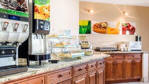 A coffee station with multiple beverage dispensers, a waffle maker, and a microwave. - Quality Inn Moriarty (Moriarty)