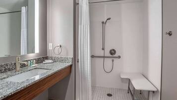Un bagno con doccia, lavandino e specchio.