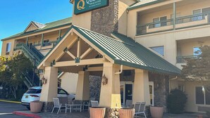 A hotel with a covered outdoor seating area, a stone facade, and a sign indicating it is a Choice Hotels property. - Quality Inn & Suites Livermore Wine Country (Livermore)