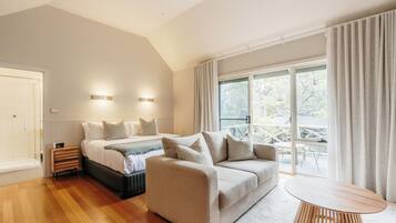 A modern bedroom with a bed, a sofa, and a table.