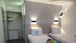Een hotelkamer met twee bedden, een inloopkast en een badkamer.