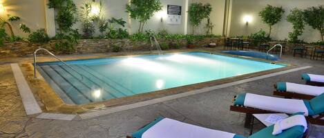 Een binnenzwembad en ligstoelen