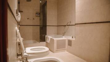 A modern bathroom with a toilet, bidet, and shower area.