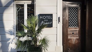 A hotel sign with the name "HOTEL DES MINES" and a wooden door with a lattice design.