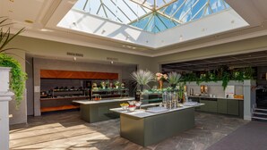 A spacious hotel lobby with a high ceiling and skylight, featuring a central island with amenities, a reception area, and a seating area. - Mount Wolseley Hotel, Golf and Spa Resort (Tullow)