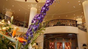A lobby with a grand chandelier, a reception desk, and a balcony with a railing. - Mount Wolseley Hotel, Golf and Spa Resort (Tullow)