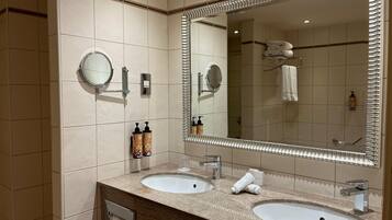 A bathroom with two sinks, a large mirror, and a towel rack.