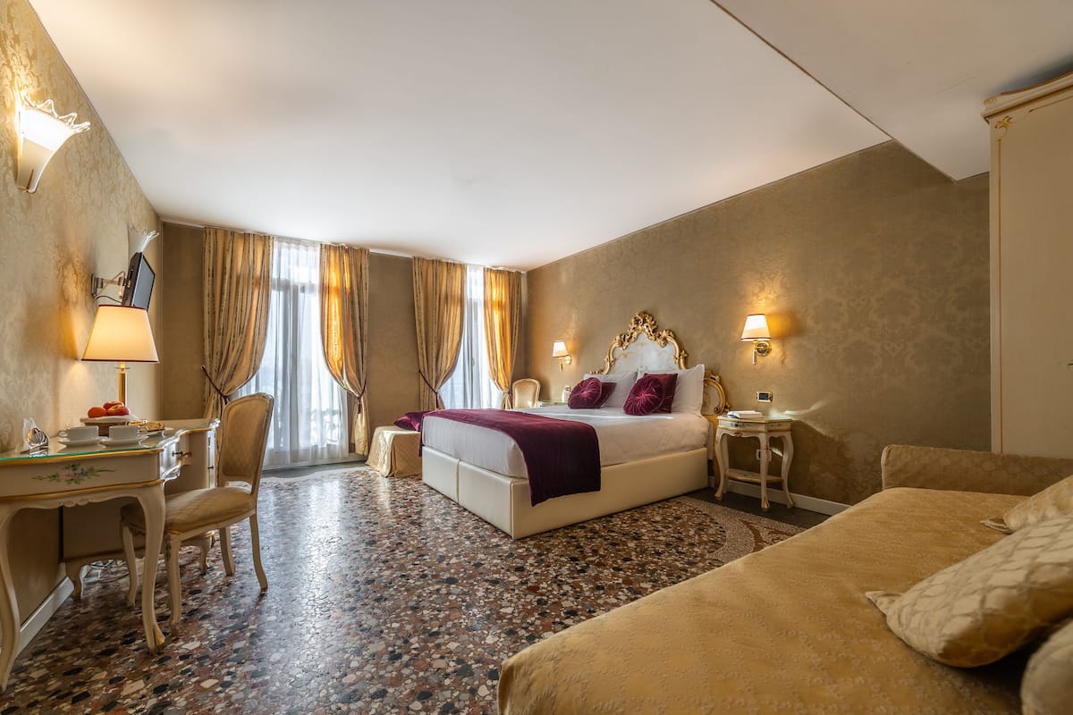 Ein Hotelzimmer mit Bett, Nachttischen, Schreibtisch und Stuhl.