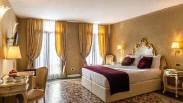 Een hotelkamer met een groot bed, een bureau met een lamp en een stoel.
