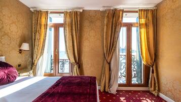 Een hotelkamer met een bed, gordijnen, een raam met uitzicht en een kamerbreed tapijt.