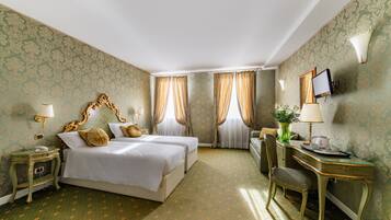 A hotel room with two beds, a desk, a chair, a TV, and a telephone.