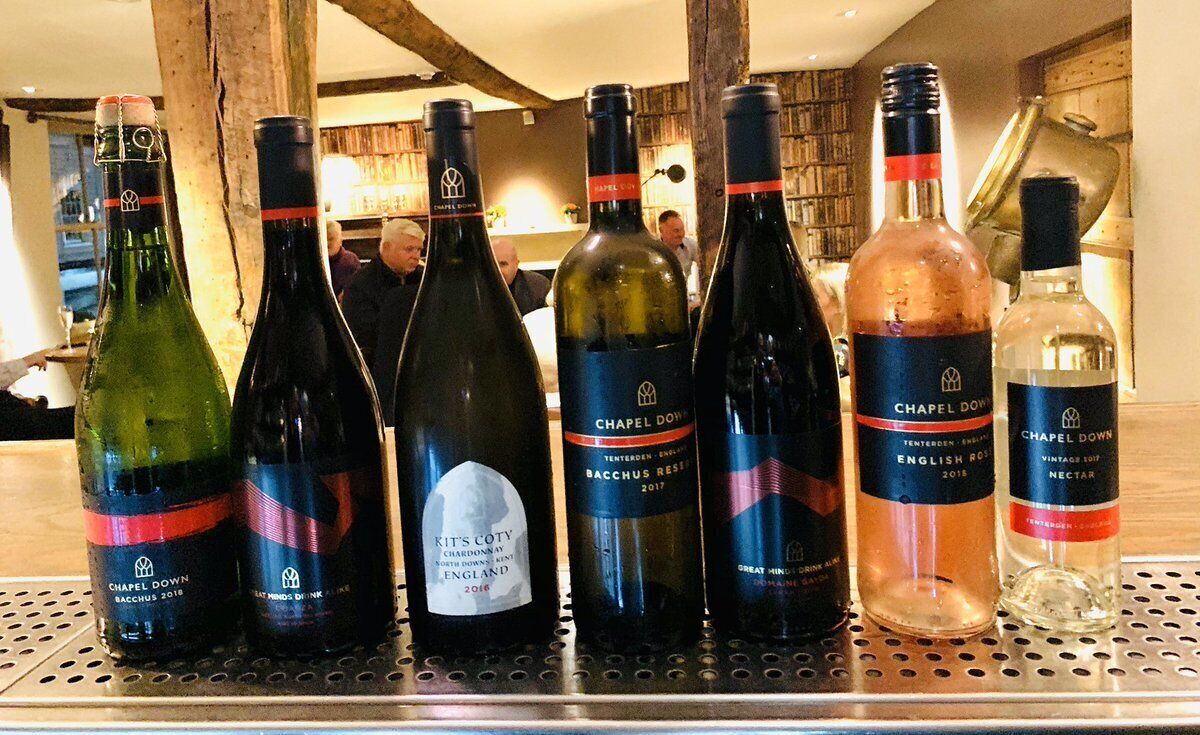 A selection of wine bottles on a metal bar counter in a restaurant setting.