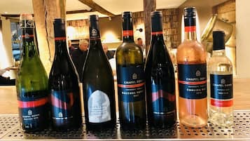 A selection of wine bottles on a metal bar counter in a restaurant setting.