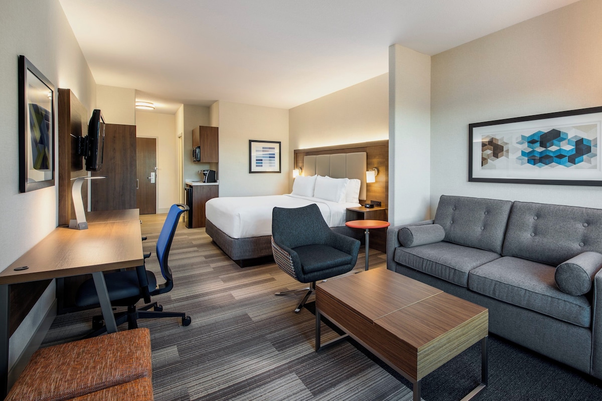 Een hotelkamer met een bed, een bank, een bureau en een stoel.