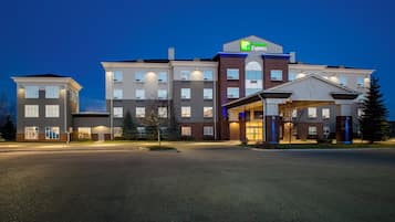 A multi-story hotel with a prominent Holiday Inn Express sign, a covered entrance, and a parking lot.