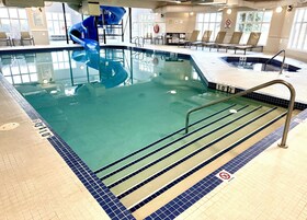 Una piscina techada, sillones reclinables de piscina