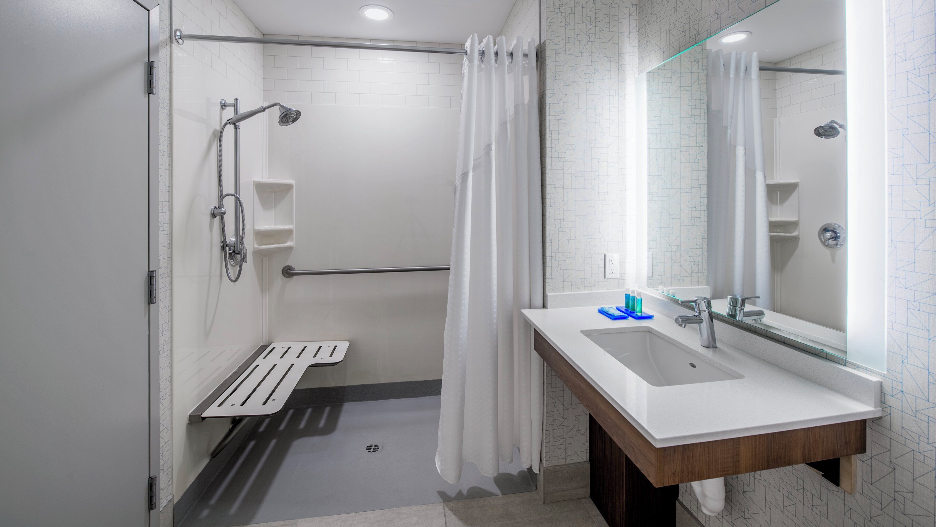 A modern bathroom with a shower, a sink, and a mirror.