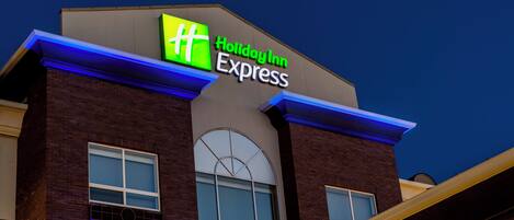 Edificio de Holiday Inn Express con un letrero llamativo, ventanas grandes y fachada de ladrillo.