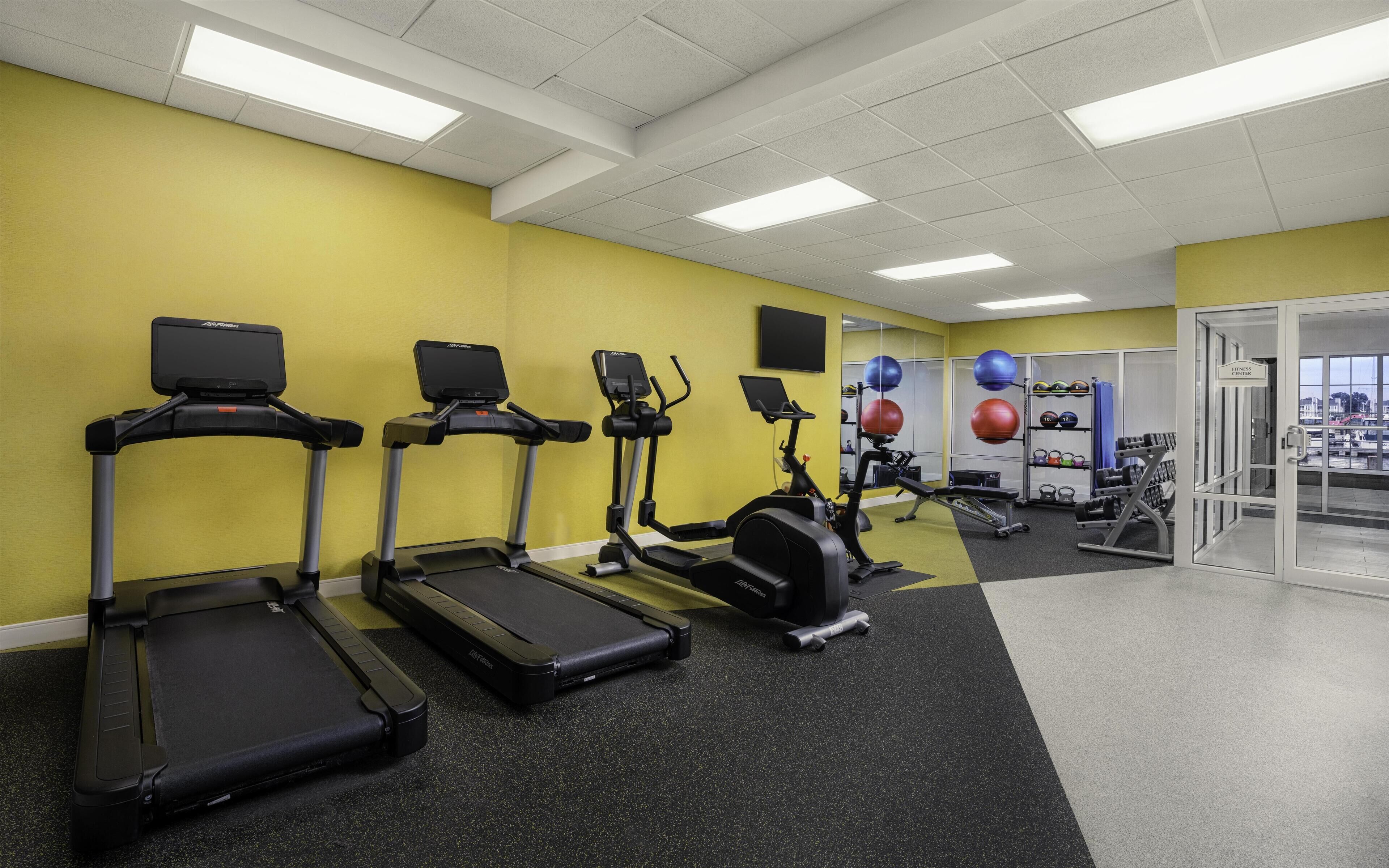Un centre de remise en forme équipé de tapis de course, de vélos elliptiques et de matériel de musculation.