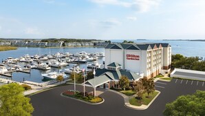 Un port de plaisance où sont amarrés de nombreux bateaux, un hôtel Hilton Garden Inn et un parking.