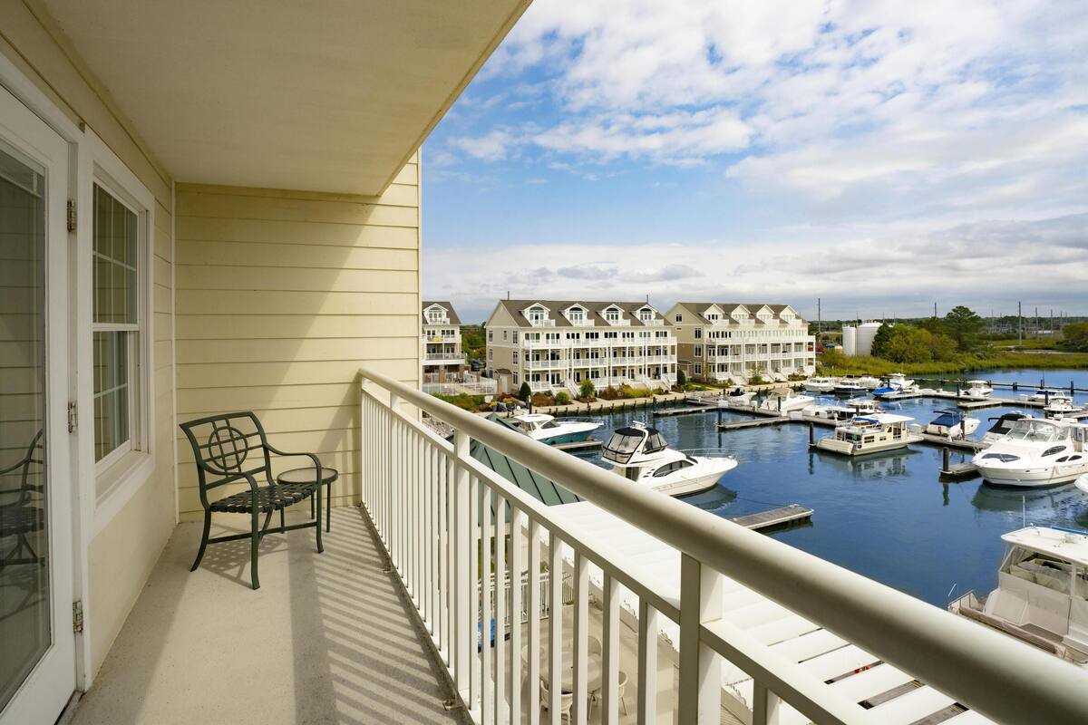 A balcony with a view of a marina and row houses.