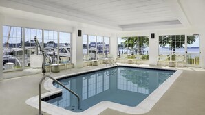 Une piscine intérieure offrant une vue dégagée sur les bateaux et l’eau.