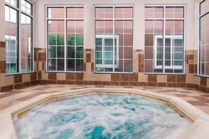 A hot tub with a tiled floor and large windows with brick walls. - Homewood Suites by Hilton Buffalo/Amherst (Buffalo)