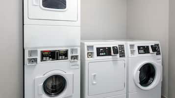 A laundry room with two stacked washing machines and a dryer.