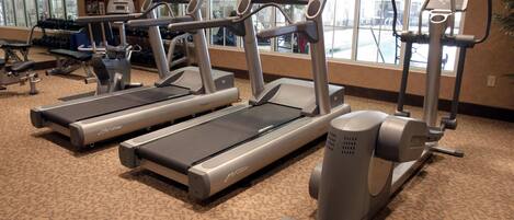 A gym with treadmills, elliptical machines, and weight equipment.