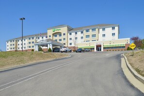 A Holiday Inn Express hotel with a covered entrance, multiple parking spaces, and a 'BUMP' warning sign.