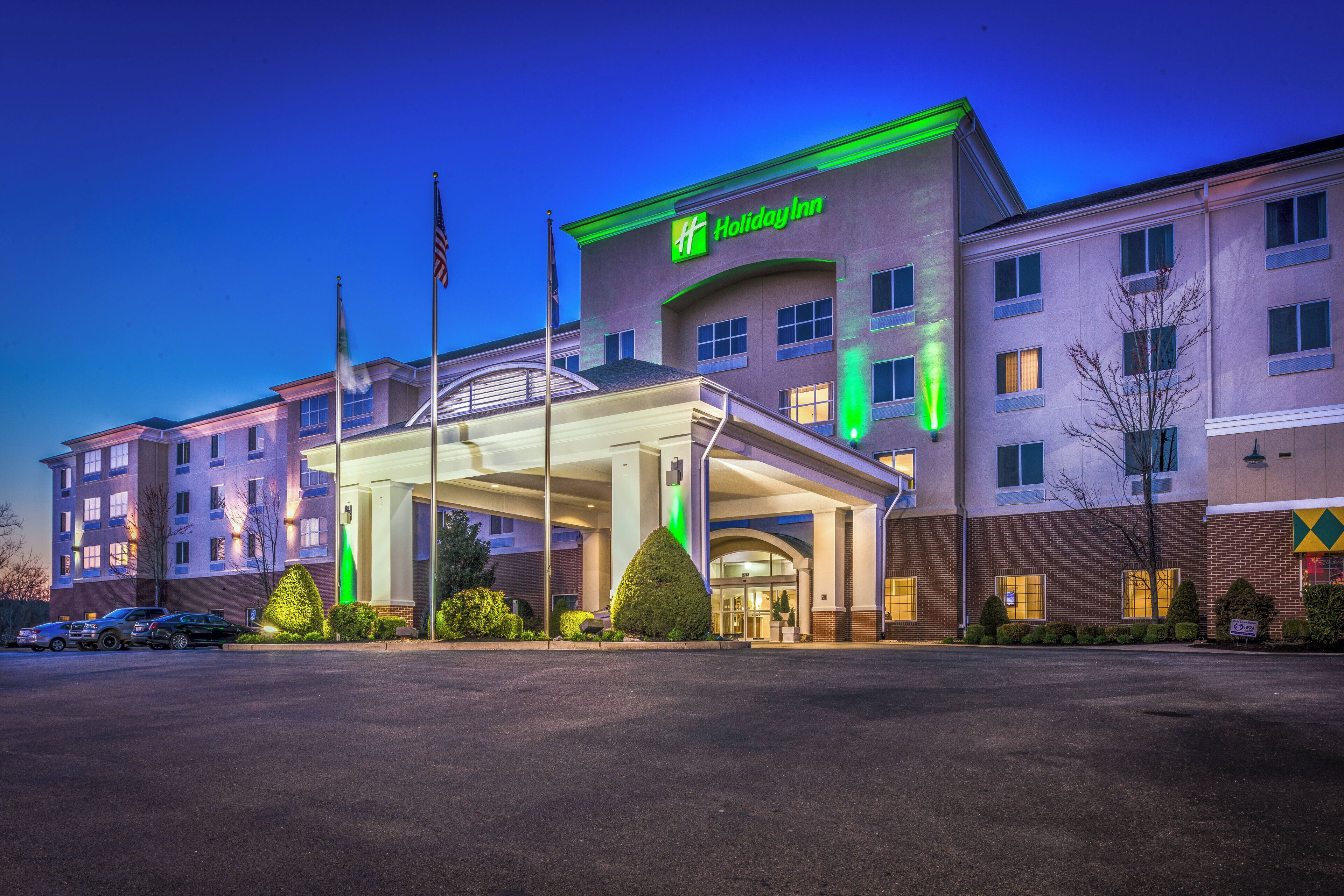 Un hôtel Holiday Inn doté d’une entrée couverte, de plusieurs étages et d’un parking.