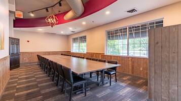 A conference room with a long table, chairs, and a large window.