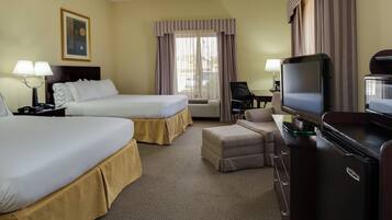 A hotel room with two beds, a desk with a television, and a chair.