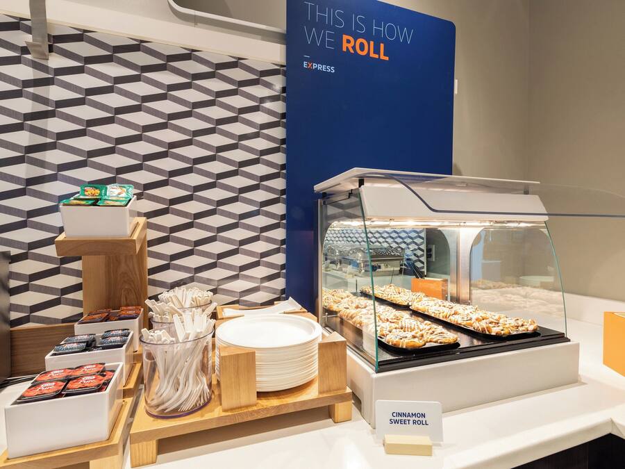 Un buffet per la colazione con un cartello che indica 'Cinnamon Sweet Roll' e una selezione di cibi per la prima colazione.