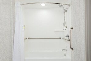 Une douche à l’italienne équipée d’une barre d’appui, d’un pommeau de douche amovible et d’un robinet amovible.
